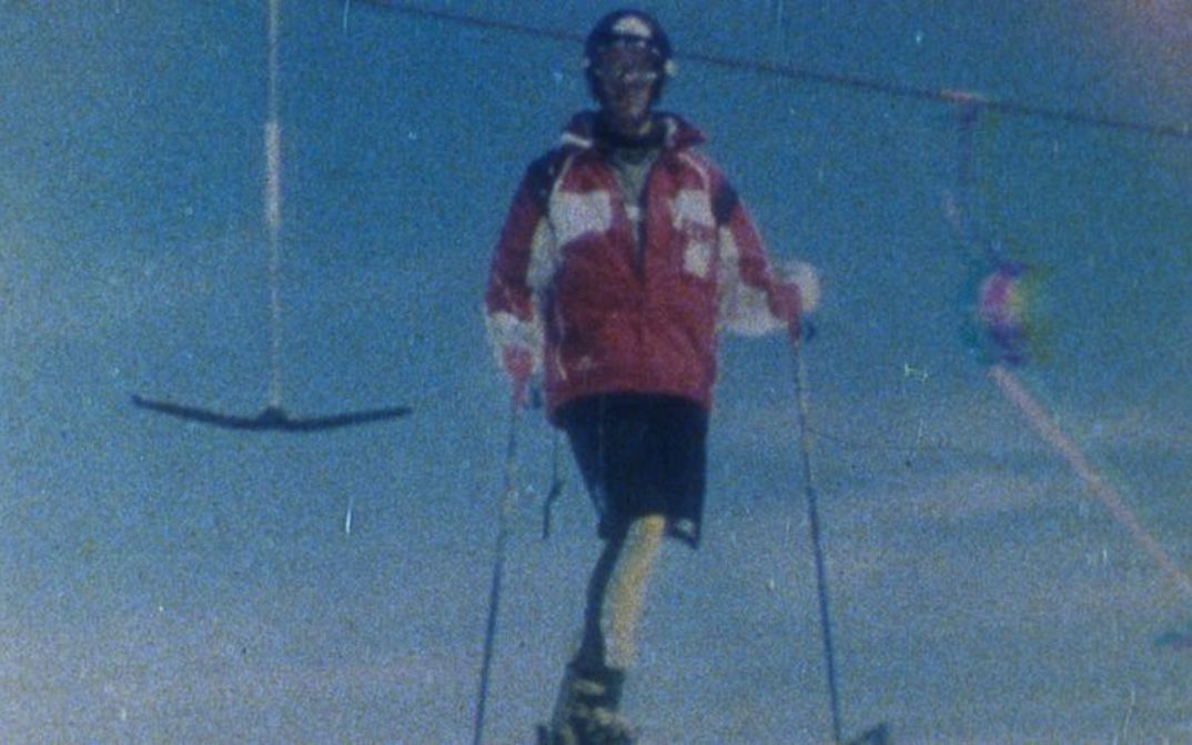 Filmstill aus SCHUSS!: Aufnahme eines Skifahrers vor einem Bügellift. Das Bild ist grobkörnig.