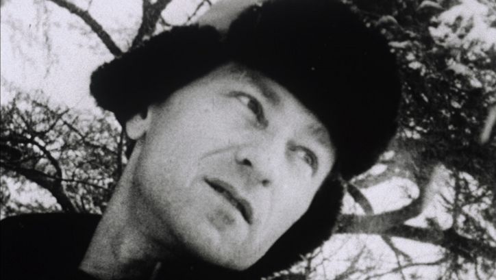 Filmstill aus LOST LOST LOST. Man sieht Jonas Mekas mit Pelzmütze, der nachdenklich in die Ferne schaut.