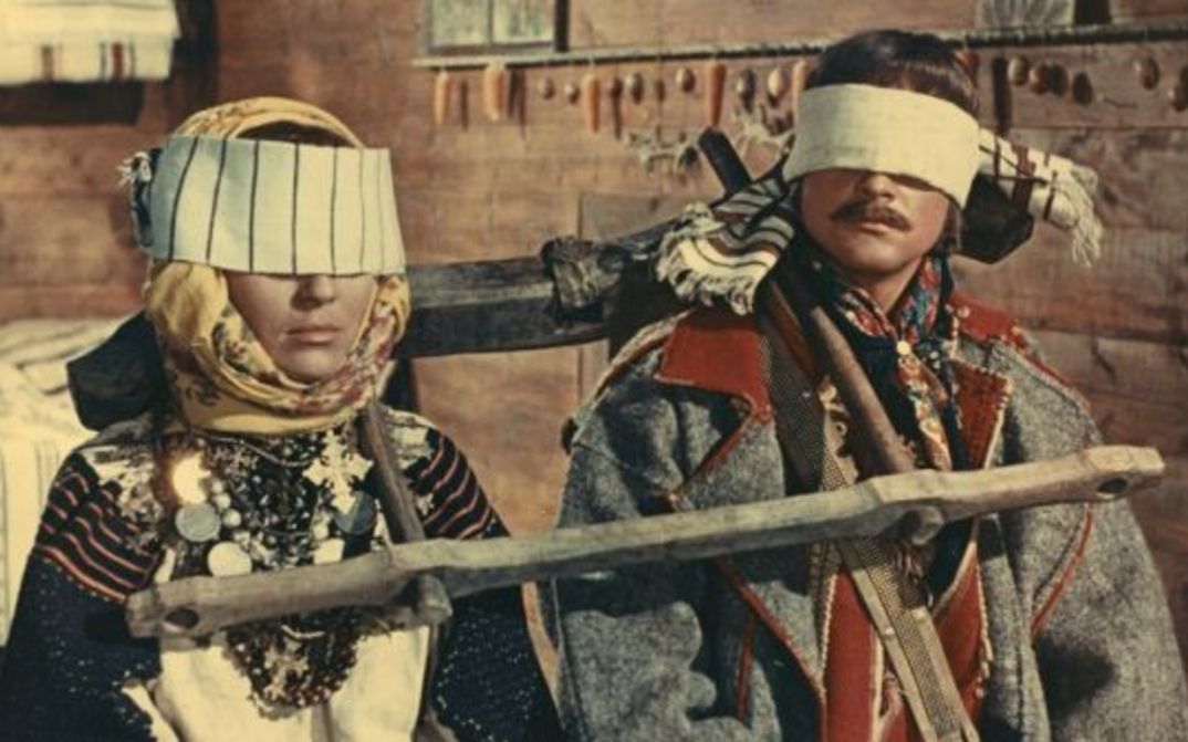 Filmstill aus SCHATTEN VERGESSENER AHNEN: Ein Mann und eine Frau in historischen Kostümen und mit verbundenen Augen.