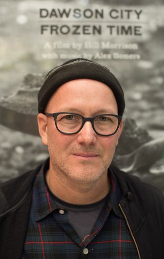 Porträt von Bill Morrison vor Filmposter