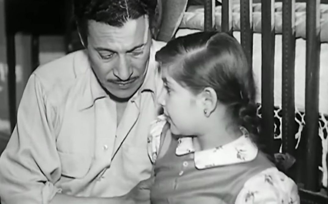 Film still from LIFE OR DEATH: A man and a girl are sitting together.