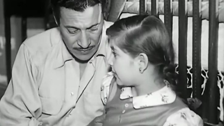 Film still from LIFE OR DEATH: A man and a girl are sitting together.