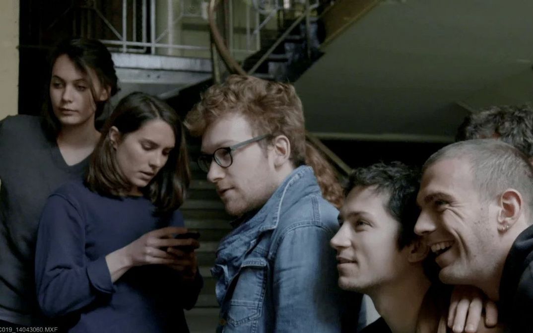 Film still from LE CONCOURS: A group of young people in a staircase.