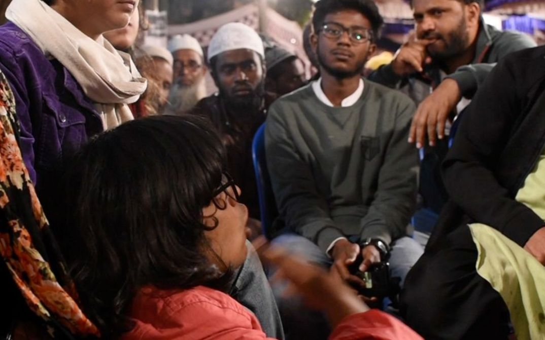 Filmstill aus dem Film "All Was Good" von Teresa A Braggs. Menschen sitzen eng beieinander und unterhalten sich angeregt.