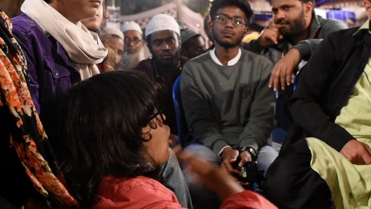 Still from the film "All Was Good" by Teresa A Braggs. People sit close together and talk animatedly.