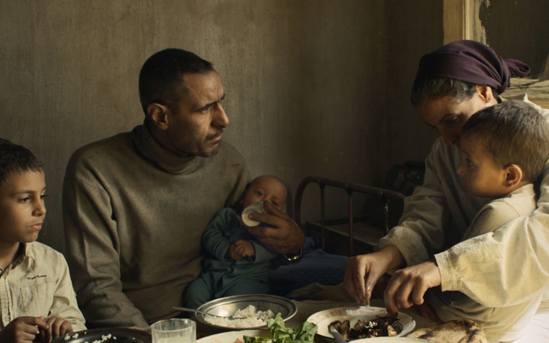 Filmstill aus FEATHERS. Eine Familie mit drei kleinen Kindern sitzt am Esstisch.