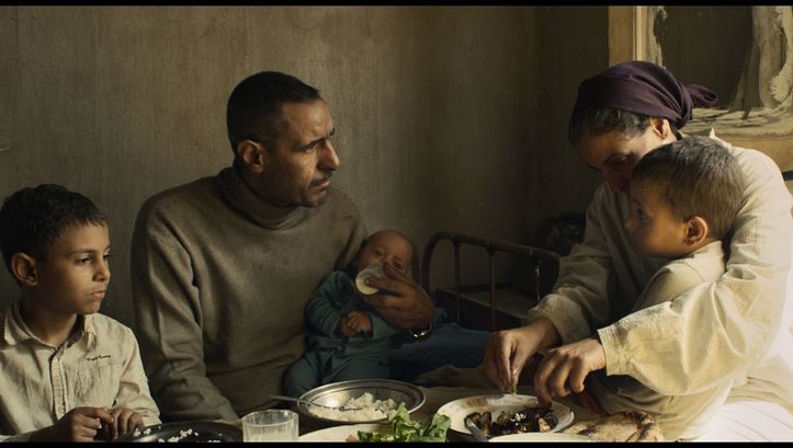 Filmstill aus FEATHERS. Eine Familie mit drei kleinen Kindern sitzt am Esstisch.