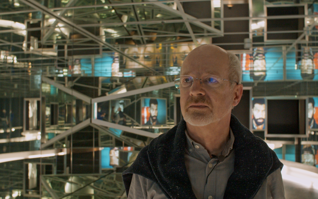 Film still from LOST AND FOUND. Martin Koerber in front of an exhibition at the Film Museum.
