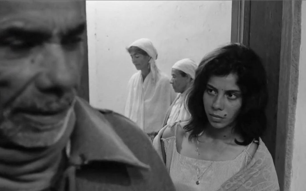 Film still from OS FUZIS: People in a small room.