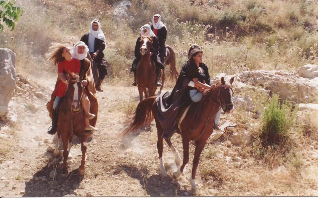 Film still from ONCE UPON A TIME IN BEIRUT. Some people on horses in a dusty landscape.
