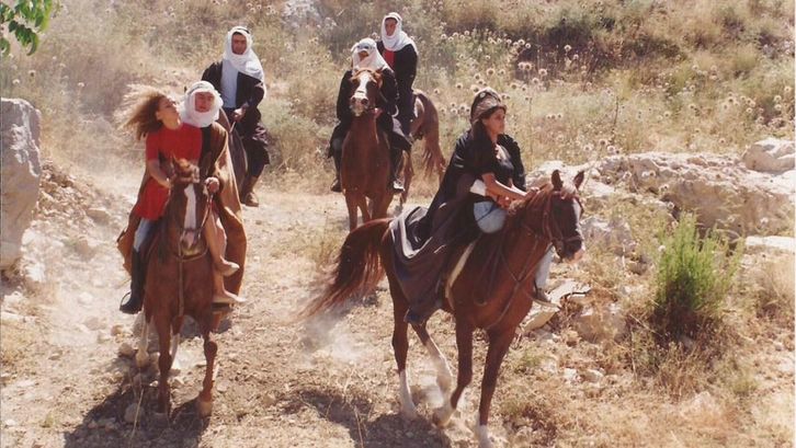 Filmstill aus ONCE UPON A TIME IN BEIRUT. Einige Menschen auf Pferden in einer staubigen Landschaft.
