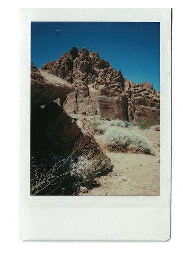 Polaroid of rocky cliffs seen from a distance.