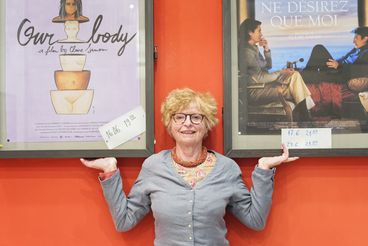 Porträt von Claire Simon vor Filmplakaten