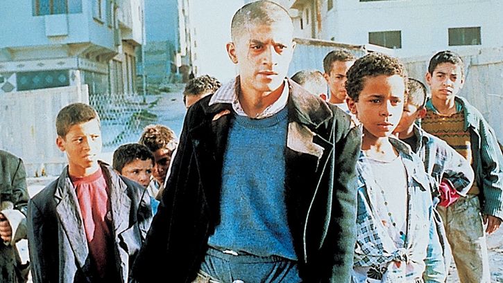 Film still from ALI ZAOUA: PRINCE OF THE STREETS: A group of youths and children on the street.