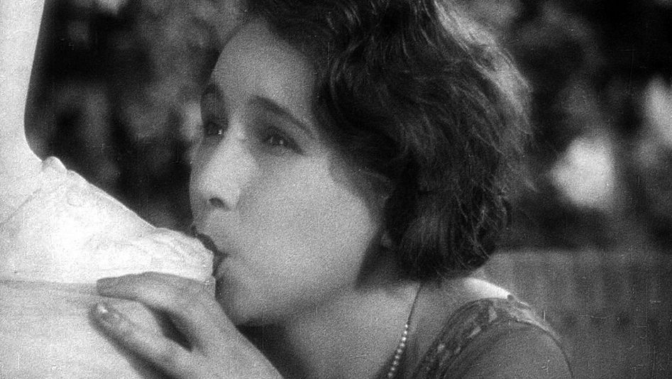 Filmstill aus L'ÂGE D'OR: Eine Frau saugt an dem Fuß einer Statue.