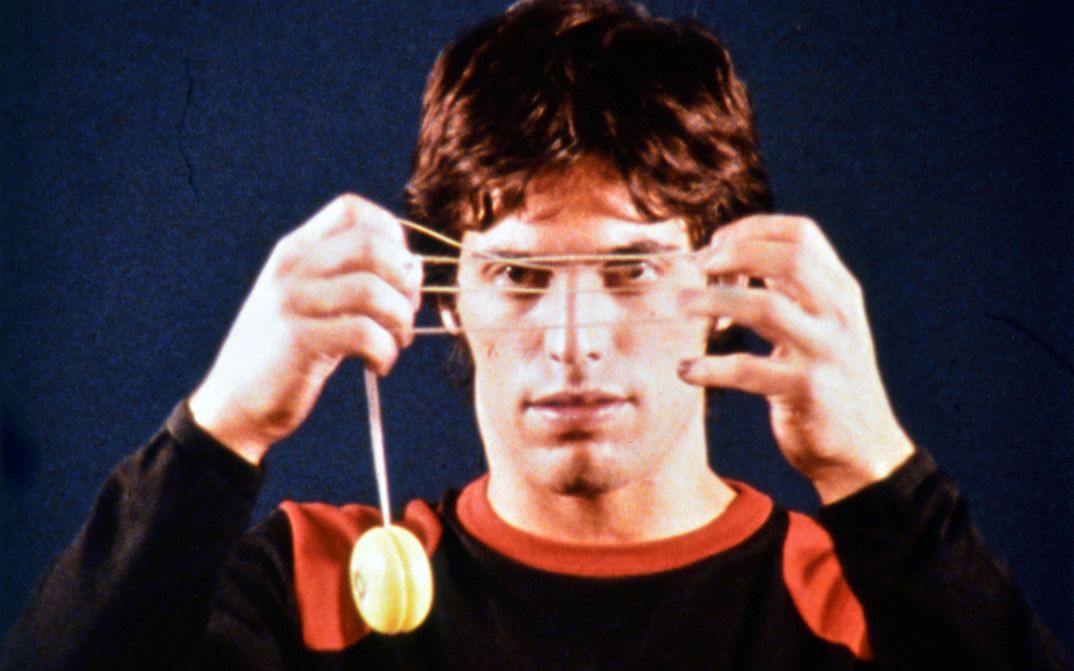 Film still from 33 Yoyo Tricks: A man is holding a yoyo in front of his face.
