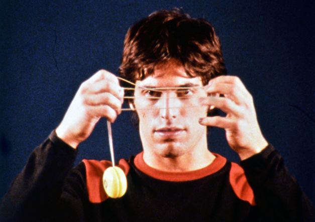 Film still from 33 Yoyo Tricks: A man is holding a yoyo in front of his face.