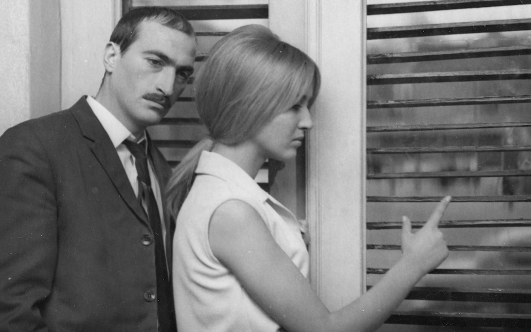 Filmstill aus LIMITS: Ein Mann und eine Frau stehen an einem Fenster, beide blicken nachdenklich.