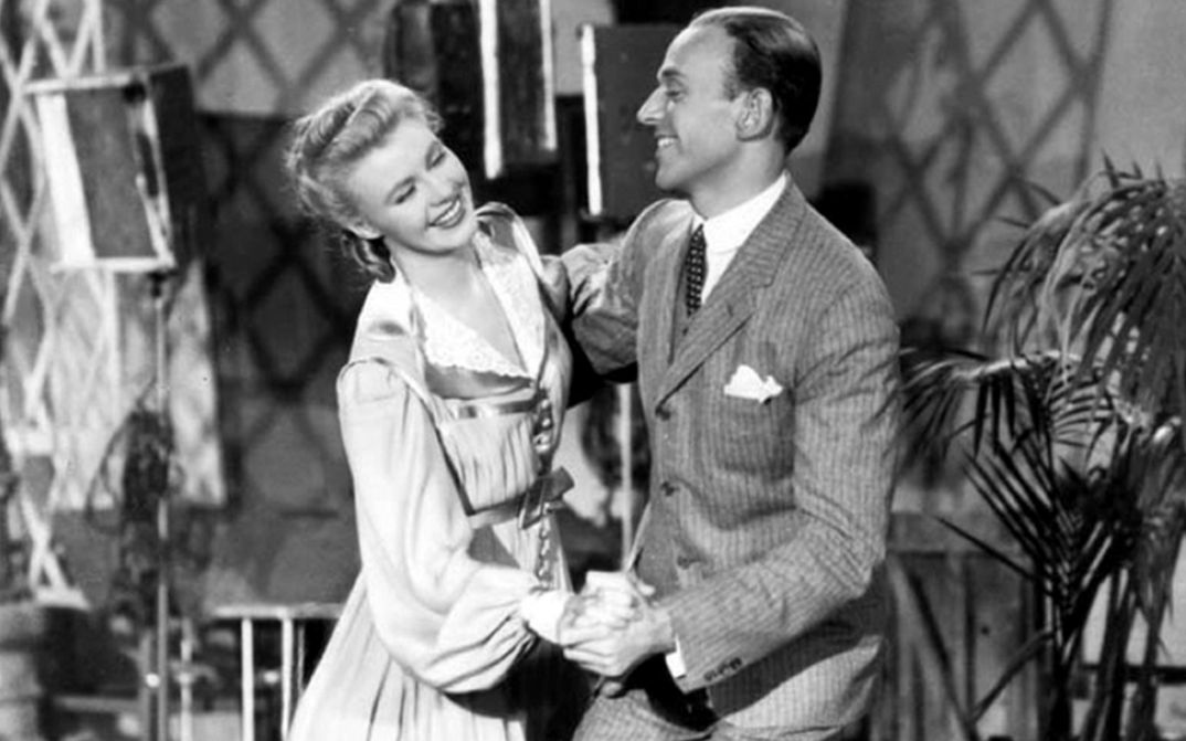 Film still from SHALL WE DANCE. Ginger Rogers and Fred Astaire dance laughing.