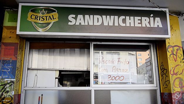 Filmstill aus „The Veteran“ von Jerónimo Rodriguez. Ein Imbiss von außen, an dem ein Schild mit der Aufschrift „Sandwichería“ hängt.