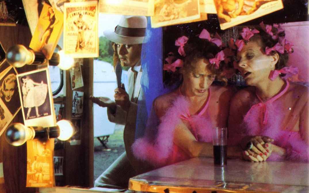 Film still from FREAK ORLANDO: Three people at a counter decorated with lots of photos.