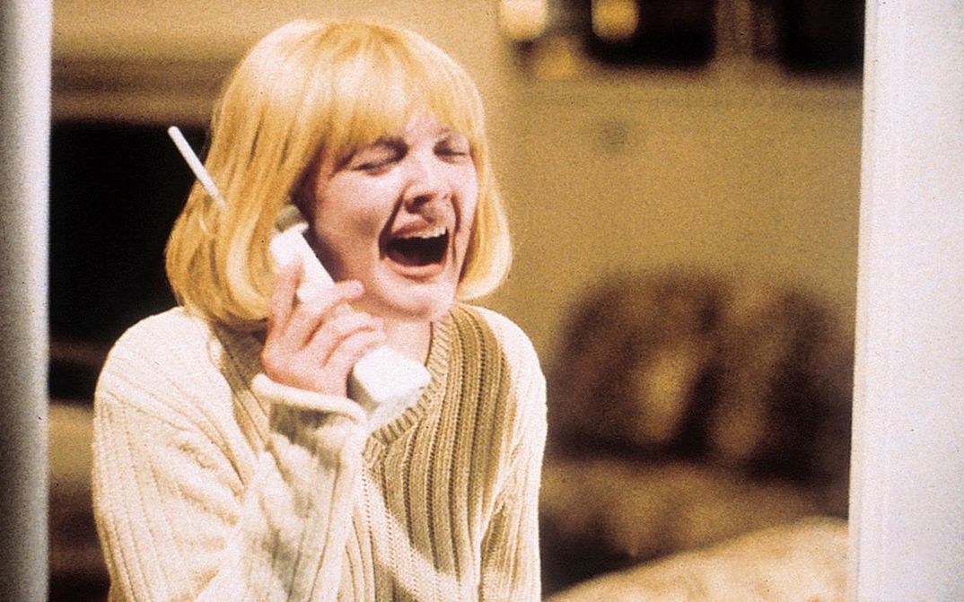 Filmstill aus SCREAM: Eine junge blonde Frau hält einen Telefonhörer ans Ohr. Ihr Gesicht ist durch einen Schrei verzerrt.