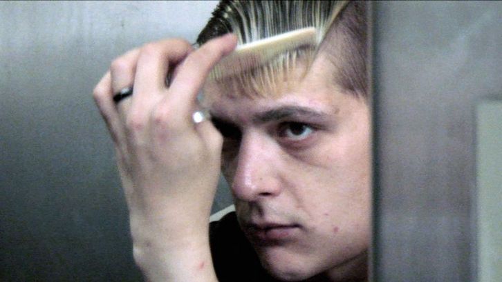 Filmstill aus DRIFTER. Ein junger Mann kämmt sich vor einem Spiegel.