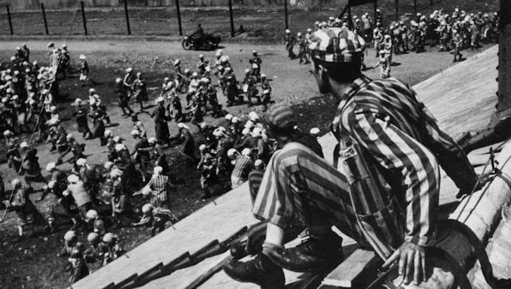 Filmstill aus THE END OF OUR WORLD: Eine Szene in einem Konzentrationslager, ein Häftling sitzt auf dem Dach einer Barracke.