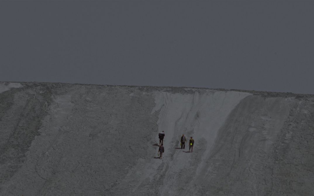 Film still from Zhou Tao’s film “The Periphery of the Base”. Four people climb what seems to be a clay hill.