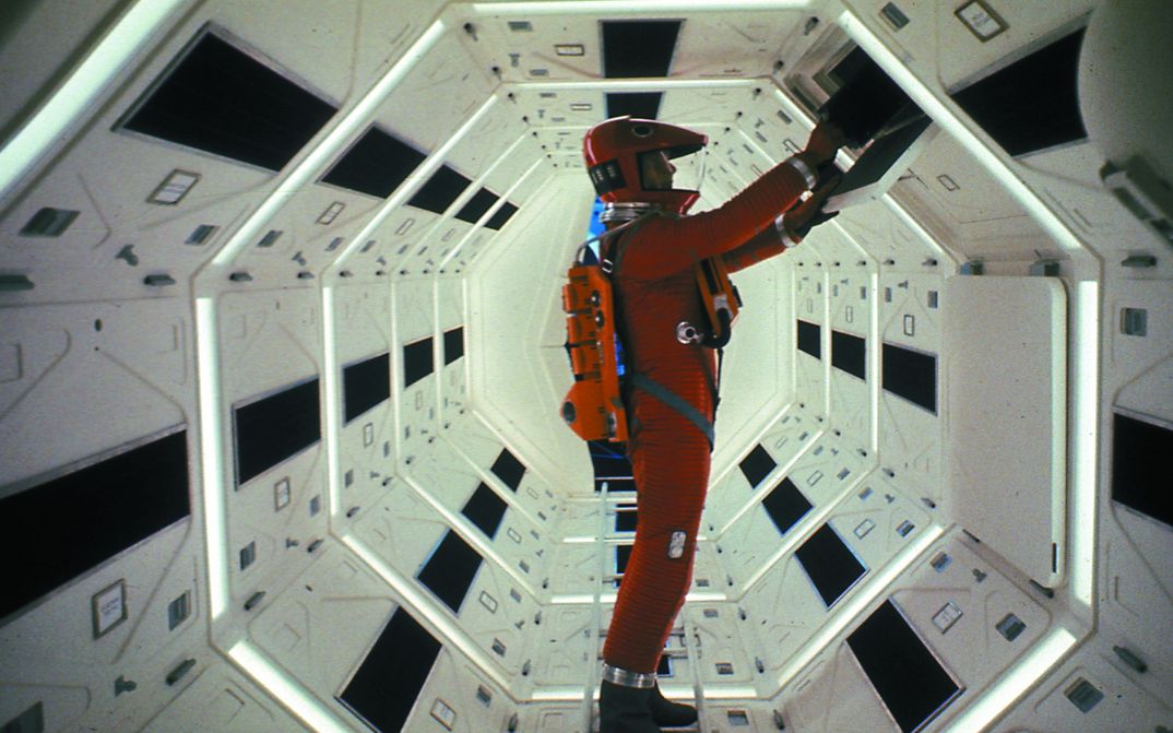 Filmstill aus 2001: Ein Astronaut in einem roten Raumanzug an einem Schaltelement.