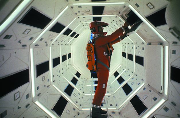 Filmstill aus 2001: Ein Astronaut in einem roten Raumanzug an einem Schaltelement.