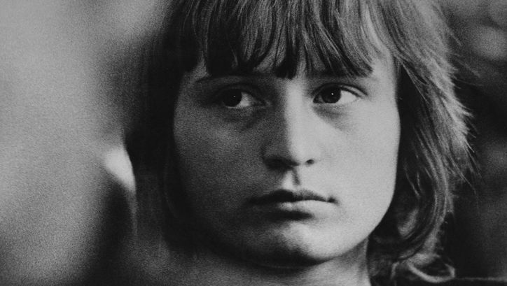 Filmstill aus ISTENMEZEJE, EIN UNGARISCHES DORF: Das Gesicht eines jungen Mädchens, ein Teil des Bildes ist leicht unscharf.