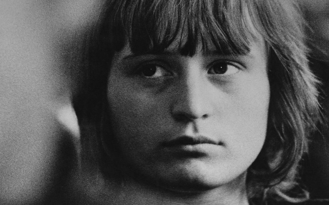 Filmstill aus ISTENMEZEJE, EIN UNGARISCHES DORF: Das Gesicht eines jungen Mädchens, ein Teil des Bildes ist leicht unscharf.