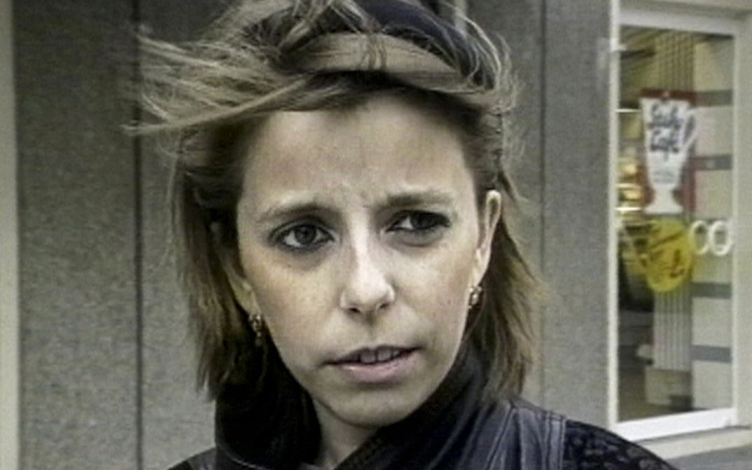Filmstill aus FORMER EAST FORMER WEST: Eine junge Frau spricht direkt in die Kamera.