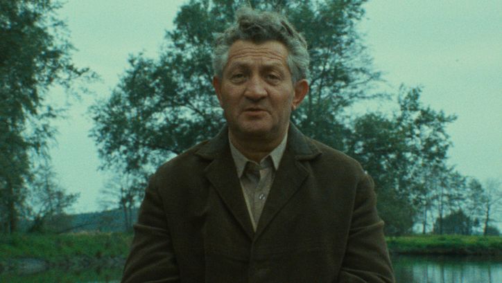Filmstill aus SHOAH: Ein älterer Mann im Gespräch, hinter ihm sind Wasser und Bäume zu sehen.