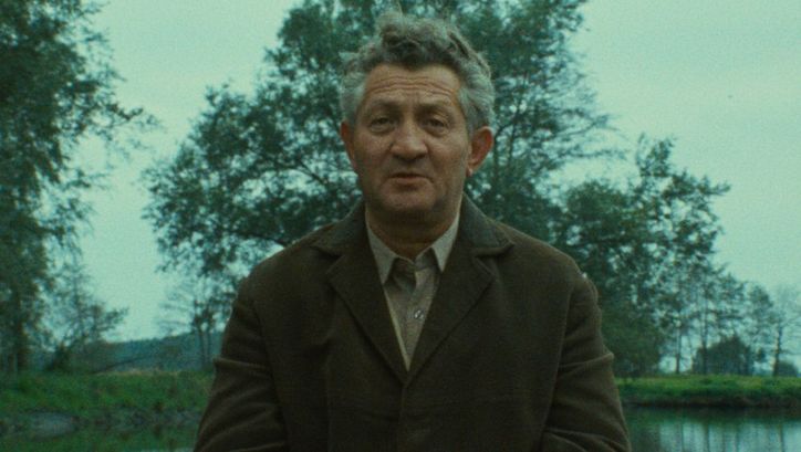 Filmstill aus SHOAH: Ein älterer Mann im Gespräch, hinter ihm sind Wasser und Bäume zu sehen.