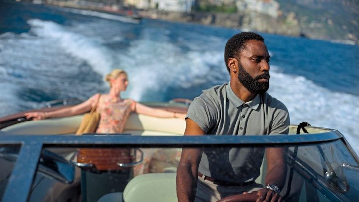 Filmstill aus TENET: Ein Mann ist am Steuer eines kleines Motorbootes, hinter ihm sitzt eine Frau.