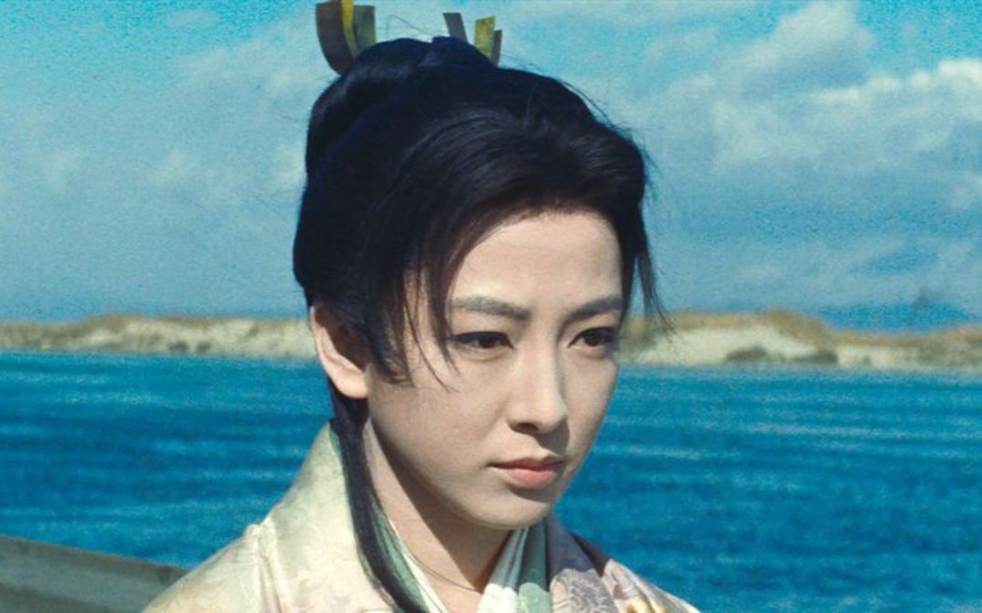 Film still from OGIN-SAMA: A woman in a traditional Japanese kimono in front of a body of water.