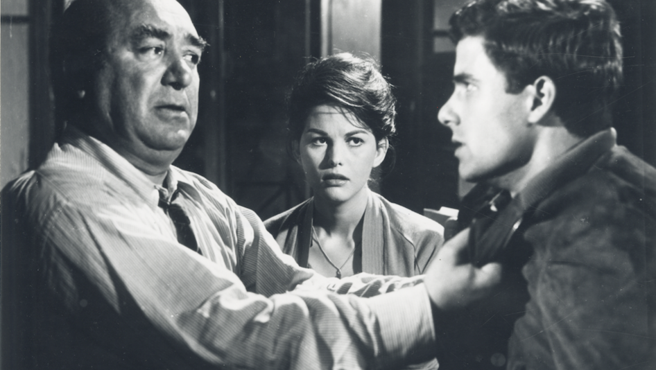 Film still from UN MALEDETTO IMBROGLIO: In the foreground are two men in an argument. A woman stands behind them and watches them.