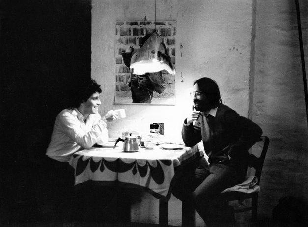Foto von den Dreharbeiten zu „In der Wüste“ von Rafael Fuster Pardo. Zwei Männer sitzen am Tisch und unterhalten sich. 