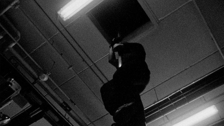 Filmstill from the Film "Fire Emergencies" by Kevin Jerome Everson.  a man slides down a fire pole.