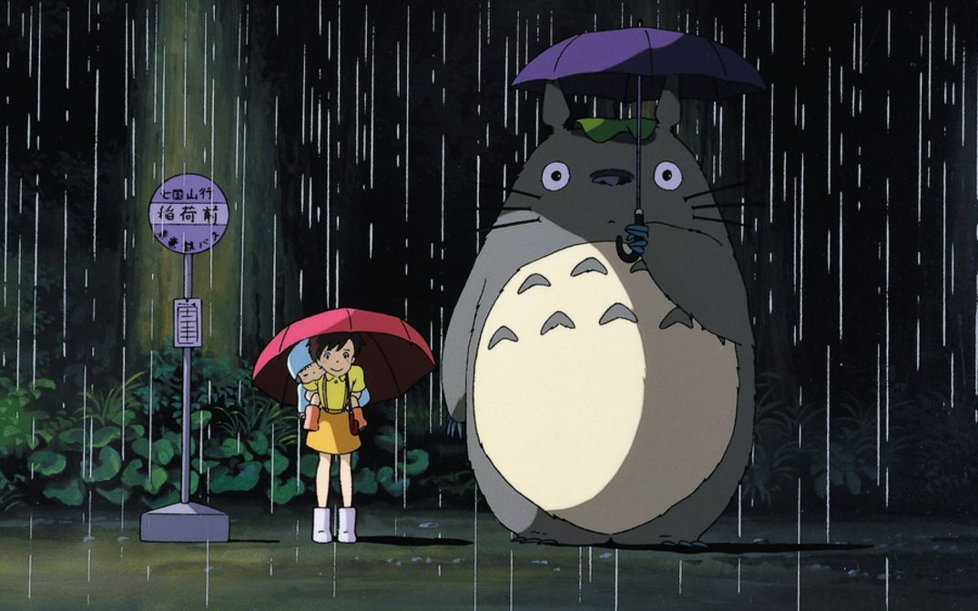 Film still from MEIN NACHBAR TOTORO: A drawing of a girl standing at a bus stop in the rain with an umbrella. Next to her is Totoro, the forest spirit, with a large, round body.