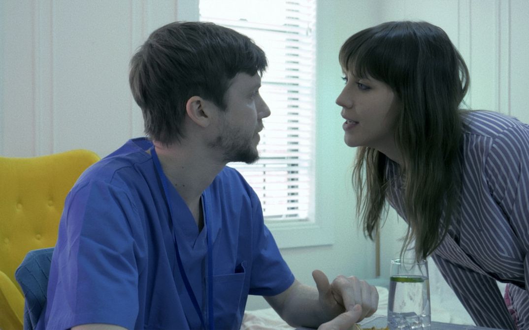 Film still from ENDURANCE: A man and a woman talking.