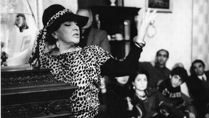 Film still from FULL CIRCLE: An actress performs in front of a group of people.