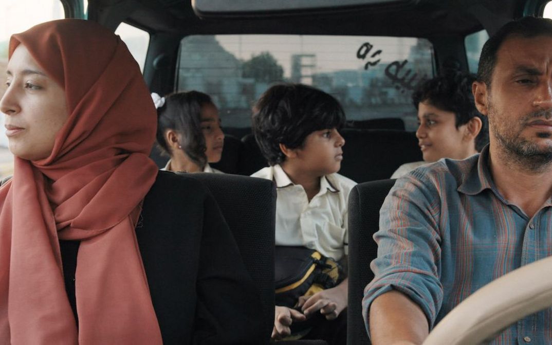 Filmstill aus THE BURDENED: Ein Paar in einem Auto, auf dem Rücksitz sitzen drei Kinder.