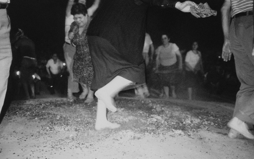 Film still from ANASTENÁRIA – DAS FEST DER FEUERLÄUFER VON LAGADÁS: A group of people walk over fire with their bare feet.
