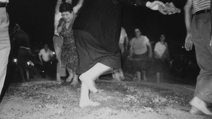 Film still from ANASTENÁRIA – DAS FEST DER FEUERLÄUFER VON LAGADÁS: A group of people walk over fire with their bare feet.