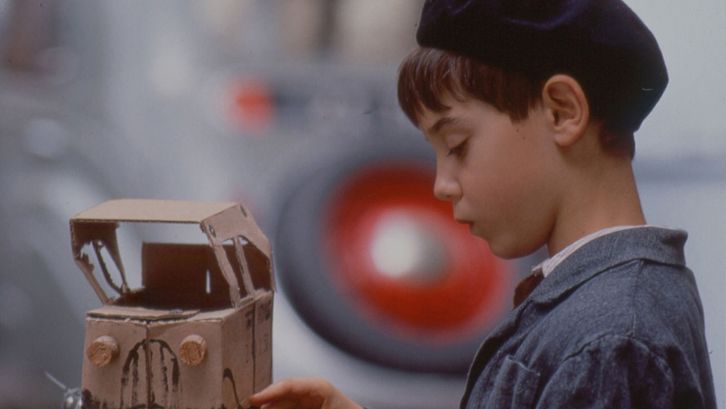 Filmstill aus JACQUOT DE NANTES. Ein kleiner Junge mit einem Spielzeugauto aus Pappe.