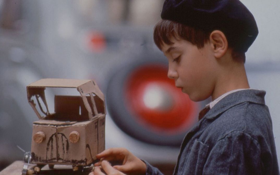 Film still from JACQUOT DE NANTES. A little boy with a toy car made of cardboard.