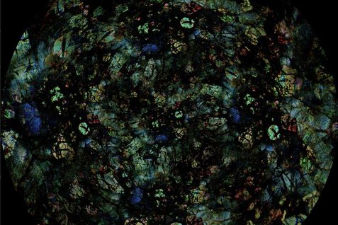 Film still from von Lisa Jackson and The Macronauts’s film “Wilfred Buck’s Star Stories”. Abstract composition resembling a kaleidoscope. The main colors are emerald green, deep blue, with touches of red and gold.